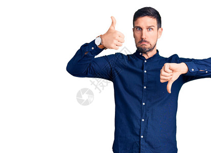 身穿散装衬衫的英俊男青年上下伸起拇指持不同意见和协议表图片