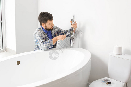 修理浴室水龙头的水管工图片