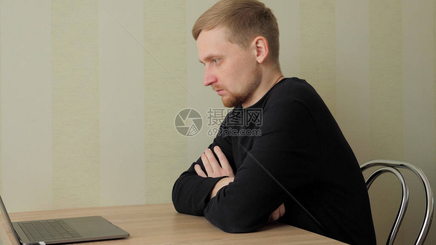 在线工作面试的人家里的那个人拿着笔记本电脑坐在桌边的椅子上隔离自我图片