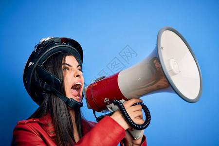 穿着古老摩托车头盔的西班牙裔女在用扩音器抗争时大发愤怒声喊着大声呼喊着朗巴口图片