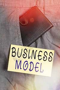 显示商业模式的书写笔记模型的商业概念显示公司如何运作以产生更多利润靠近符号纸的裤子前图片