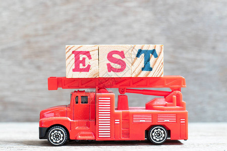 红色消防车在木材背景上用字封规定估计东部时区表示序列标记图片