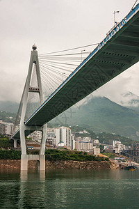 长江西陵峡谷在绿水和高层建筑之上的巴东吊桥的一部分下图片