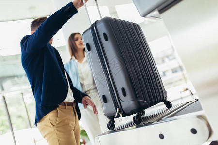 商业旅行者将行李装在X光机上图片