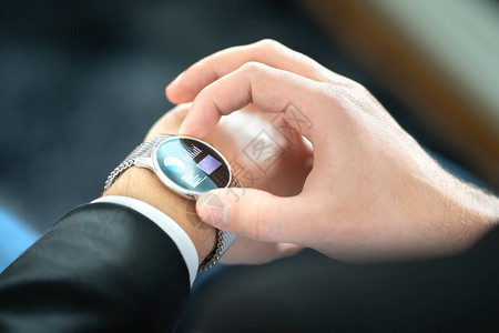 带触摸屏的智能手表使用具有移动技术的可穿戴设备的商人带有财务报告或银行应用程序的智能手表手里拿着数字小玩意的人混合可背景图片