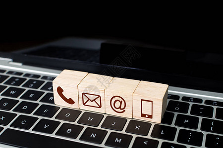 笔记本电脑键盘上的木块符号电话邮件地址和手机网站页面与我们联系或电子图片