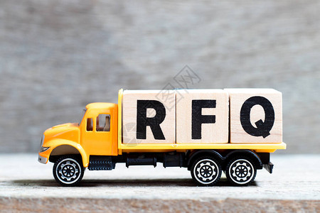 卡车在木材背景上持有用RFQ字写的字母块图片