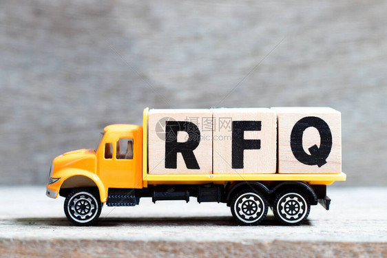 卡车在木材背景上持有用RFQ字写的字母块图片