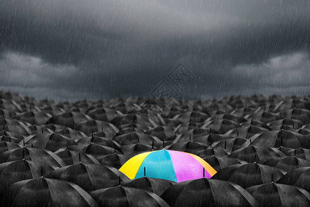 在大量的黑色雨伞中的彩色雨伞图片