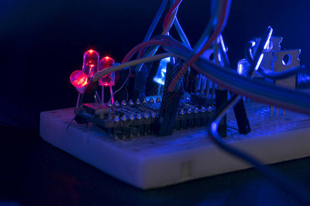 面包板arduino纳米原型板晶体管电阻器LED红色和蓝色在黑色皮肤上背景图片