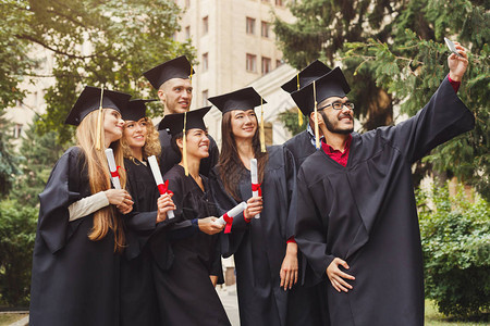 一群多民族学生在智能手机上自拍庆祝毕业教育资图片