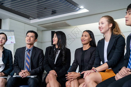 年轻的亚洲和高加索观众在办公室的小组会议演示中坐着听演讲者商人和女企业家在培训车间国际图片