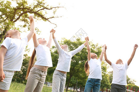 一群儿童手举在公园里握手图片
