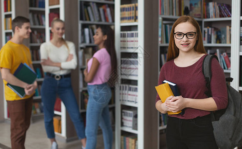 学生活方式戴眼镜的女学生在一群学生面前摆姿势图片