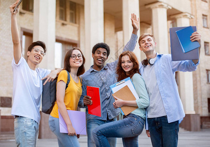 快乐的一年级学生在大学楼外摆姿势图片