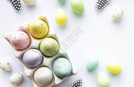 五颜六色的复活节彩蛋在白色背景上的托盘复活节假期概念图片