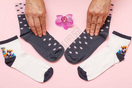 女手和女袜子在粉红色背景上背景图片