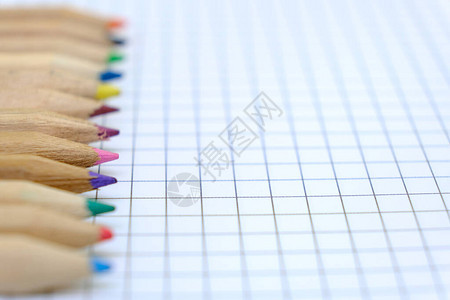 特写一组彩色铅笔在记本格子纸上用于绘图回到学校的概念复制空间图片