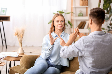 在家里使用手语的年轻聋哑夫妇图片