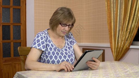 老妇人不明白如何使用平板电脑图片