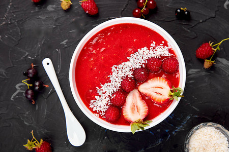 黑色背景的健康的早餐碗草莓和椰子的树莓香水维冈食品顶图片