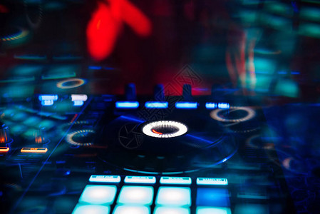 在夜总会混合有彩色效果的音乐的专业DJ图片
