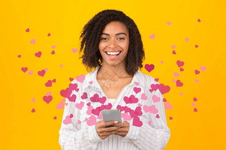 黑人女在手机上发送和接收爱情短片时的肖像图片