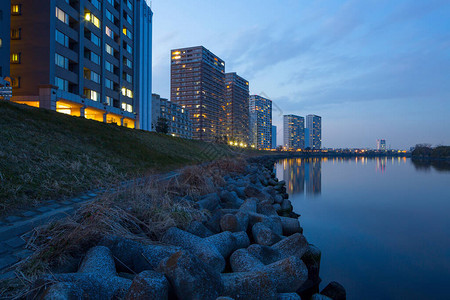 沿河的公寓和反射的夜景图片