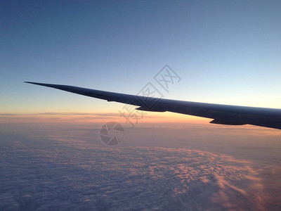 在日落期间飞越云层背景图片