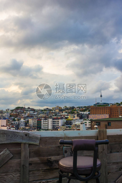 木制阳台上的城市景观前景是一把椅子雨前多云的天空单程冷静图片