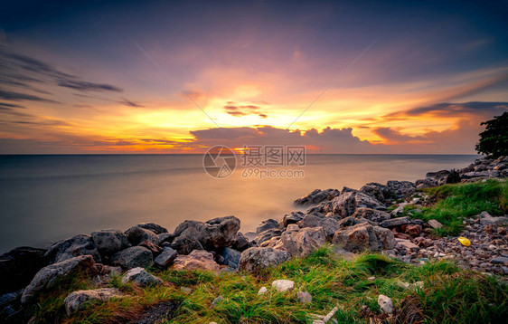 日落时在石滩上的岩石美丽的海滩日落天空暮色大海和天空黄昏的热带海戏剧天空和云彩平静和放松的生活自然景观宁图片