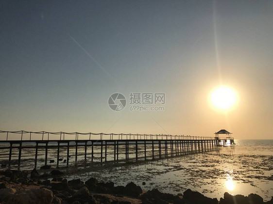 埃及海边的早晨日出在明亮的夏天光芒背景的木码头一大圈太阳在海洋上图片