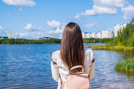 带着背包的黑发女孩享受着令人惊叹的景色湖与美丽的景观冒险自图片