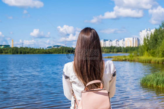 带着背包的黑发女孩享受着令人惊叹的景色湖与美丽的景观冒险自图片