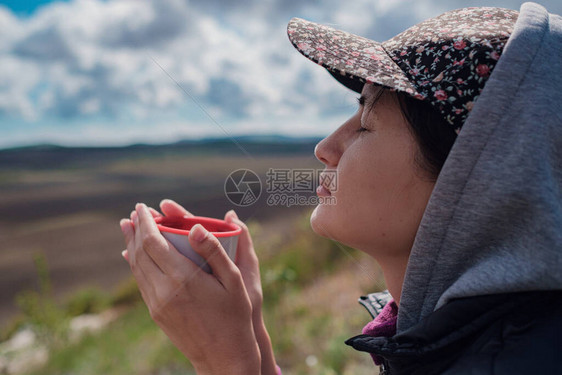 穿着帽子的旅游女孩拿着杯子图片