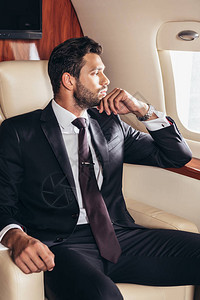 穿着西装的英俊商人在私人飞机上图片
