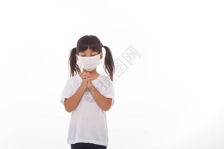 亚洲女孩戴着面具保护pm25和冠状Covid19呆在家里向上帝祈祷周日在线教堂礼拜亚洲小女孩在家祈祷社交距图片