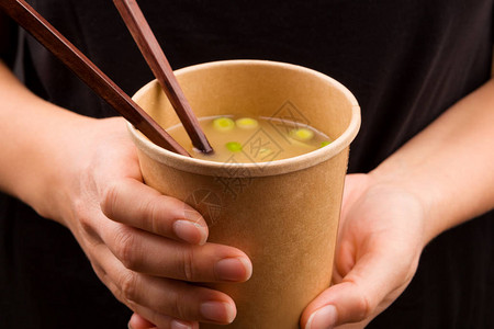 在旅途中吃饭的女人外卖杯中的味噌汤传统的亚洲美食图片