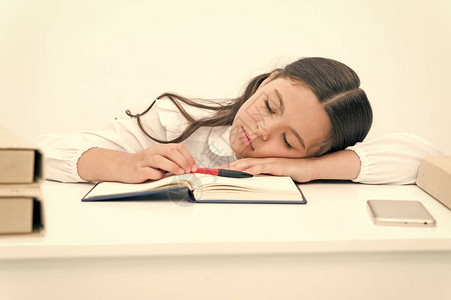 无聊的女学生睡午觉小女孩在书桌打盹现图片