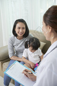 亚洲年轻女带着孩子坐在沙发上图片