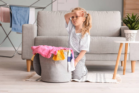 亚洲的小女孩在厨房里洗盘子照片  |穿脏衣服的小女孩在颜色背