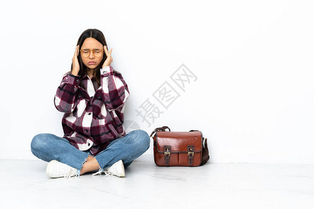 坐在地板上头痛的年轻女学生背景图片