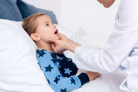 穿白大褂的医生检查生病的孩子图片