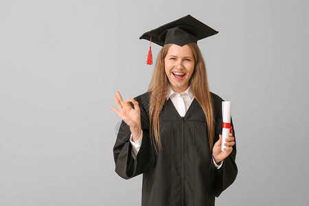 毕业女学生毕业文凭在轻背景上显示有图片