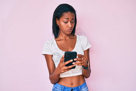 年轻非裔美国女使用智能手机怀疑和紧张图片