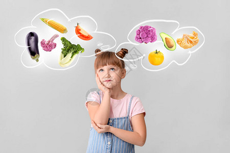秋叶透着光小女孩想象着不同的健康蔬菜在轻光背景背景