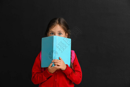 有书在黑暗背景的小女学生图片