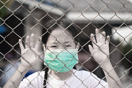 小姑娘在笼子里戴着医疗保护面罩图片