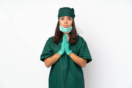 身穿绿色制服孤立在白色背景上的外科女保持棕榈在一起图片