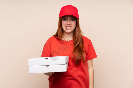 比萨饼送货少女拿着比萨饼在孤立的背景下怀疑和困惑的表情图片